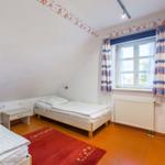 Zimmer mit zwei Betten, Fenster und Heizkörper