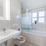 Badezimmer mit Badewanne, Dusche, Waschbecken und Toilette.