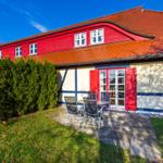 Rotes Fachwerkhaus mit Terrasse und Garten.