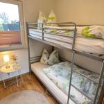 Zimmer mit Doppelstockbett, Fenster und kleinem Tisch mit Lampe.