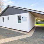 Ferienhaus Annika mit Garage und Gartenbereich. Modernes Gebäude mit weißen Wänden.