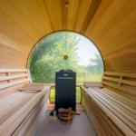 Sauna mit Holzbänken und runden Fensterblick auf Grün