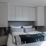 Schlafzimmer mit Bett, Kopfteil und integrierten Schränken.