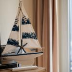 Ein Segelschiffmodell mit Segeln und Sternfisch steht auf einem Holztisch.