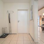 Flur mit Garderobe und Blick in Wohnbereich mit Sofa und Tisch