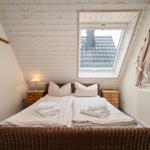 Schlafzimmer mit Dachfenster, Bett und Nachttischen