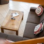 Ein Sofa mit Kissen und einem Holztisch mit Lighthouse-Modell.