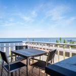Terrasse mit Tisch und Stühlen bietet Meerblick.