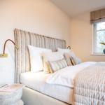 Schlafzimmer mit Bett, Fenster und Nachttisch.