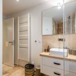 Badezimmer mit Waschtisch, Spiegel und Dusche