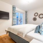 Schlafzimmer mit Bett, TV und Fenster zur Aussicht.