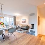 Wohn- und Essbereich mit Sofa, Esstisch und Kamin.