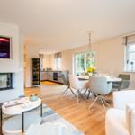 Wohn- und Essbereich mit Kamin, Esstisch und Küchenbereich.