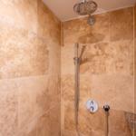 Dusche mit Duschbrause und Handbrause an Wand