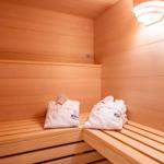 Sauna mit Holzbank und weißen Handtüchern