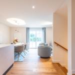 Eingangsbereich mit Treppenhaus, Essbereich und Wohnzimmer mit Sitzgelegenheiten.