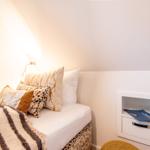 Schlafzimmer mit Bett, Kissen und integriertem Schrank.