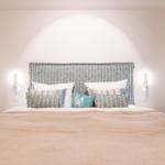 Schlafzimmer mit Bett, Kopfteil und Wandlampen