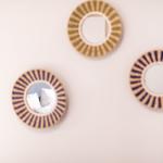 Drei runde Spiegel mit geflochtenen Rahmen an der Wand.