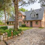 Haus mit Backsteinfassade und Steinmauer im Garten
