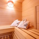 Sauna mit Holzbank und weißen Handtüchern
