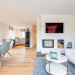 Wohn- und Essbereich mit Kamin, Sofa und Esstisch.