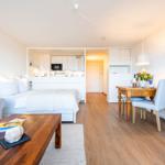 Schlafzimmer mit Bett, Sofa, Esstisch und Küchenbereich.