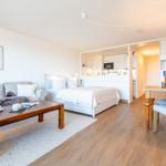 Wohnbereich mit Sofa, Bett, Esstisch und Küchenbereich.