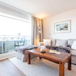 Wohnzimmer mit Sofa, Couchtisch und Balkonansicht.