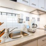 Küche mit Spüle, Kochfeld und Küchengeräten.