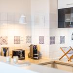 Küche mit Mikrowelle, Toaster und Kaffeemaschine an der Arbeitsfläche.