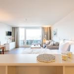 Ein Schlafzimmer mit Blick auf Balkon, Sofa und Esstisch.