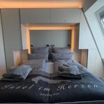 Schlafzimmer mit Doppelbett, eingebauter Schrank und Dachfenster.