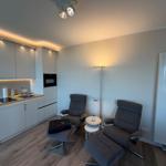 Küche mit zwei Sesseln und Fußstützen. Moderne Einbauküche mit Licht.