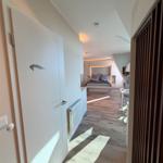 Schlafzimmer mit Bett, Tisch und Holzboden. Tür mit Delfinmotiv.