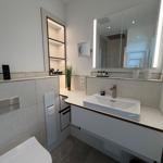 Moderne Badezimmer mit Waschtisch, Spiegel und Toilette.