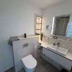 Badezimmer mit Waschbecken, Spiegel und Toilette