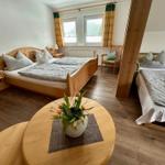 Zwei Schlafzimmer mit Holzbetten und Fenstern mit Vorhängen.