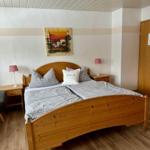 Schlafzimmer mit Holzbett, Nachttischen und Wandbild.