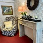 Eingangsbereich mit Sessel, Schminktisch und Dekoration.