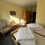 Ein Schlafzimmer mit Bett, zwei Stühlen, Tisch und Kleiderschrank.