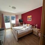 Schlafzimmer mit Bett, Nachttischen und Fenster mit Blick auf die Berge.