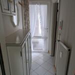 Flur mit Garderobe, Heizkörper und Tür zum Außenbereich.