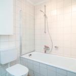 Badezimmer mit Badewanne, Duschbrause und Toilette.