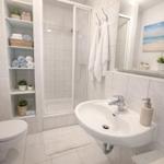 Badezimmer mit Dusche, Waschbecken und Toilette. Regal mit Handtüchern und Pflanzen.
