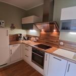 Küche mit Holz Arbeitsplatte, Herd, Spüle und Kühlgerät.