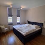 Schlafzimmer mit Bett, Stuhl und Fenstern