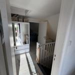 Hausflur mit Garderobe, Teppich und Treppenhaus zur oberen Etage.