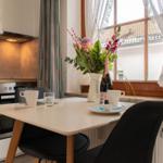 Essbereich mit Tisch, Stühlen und Blumen am Fenster