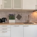 Küche mit weißen Schränken, Holz Arbeitsplatte und Lavendel Pflanze.